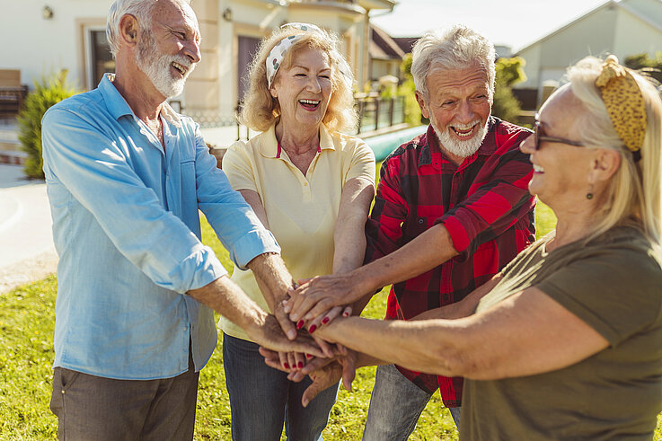 Senior people holding hands in the middle before a football match