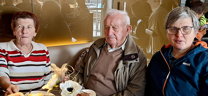 Sitzend - 2 Frauen, ein Mann