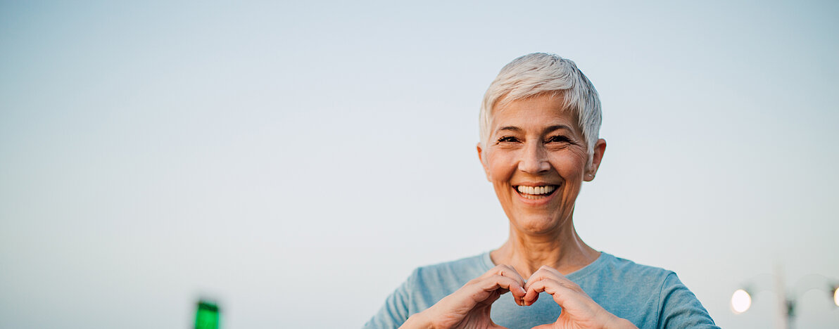 Active senior woman making a heart with her hands