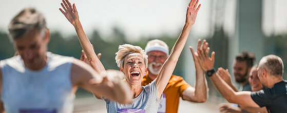 Happy senior woman celebrating her end of marathon race.