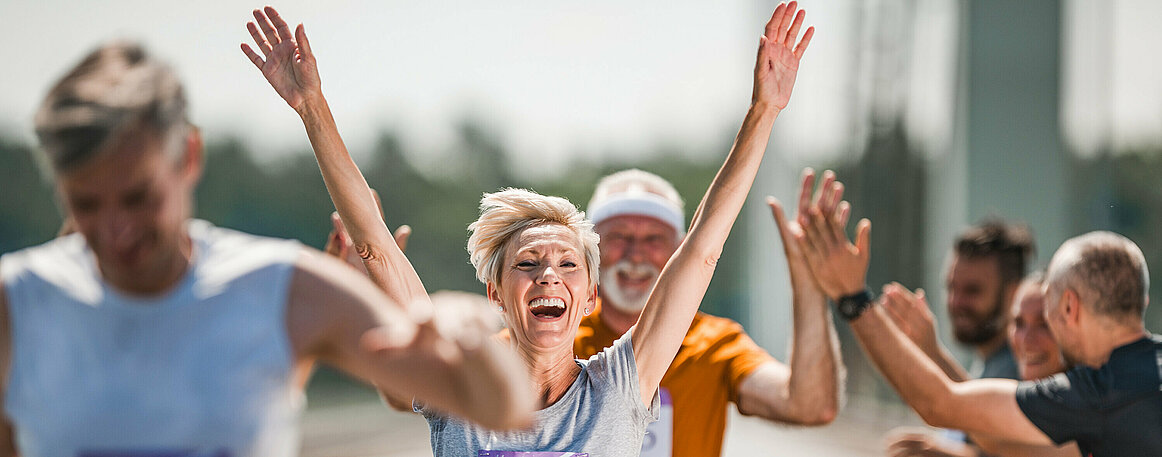 Happy senior woman celebrating her end of marathon race.