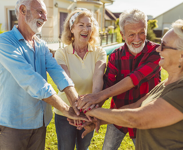 Senior people holding hands in the middle before a football match