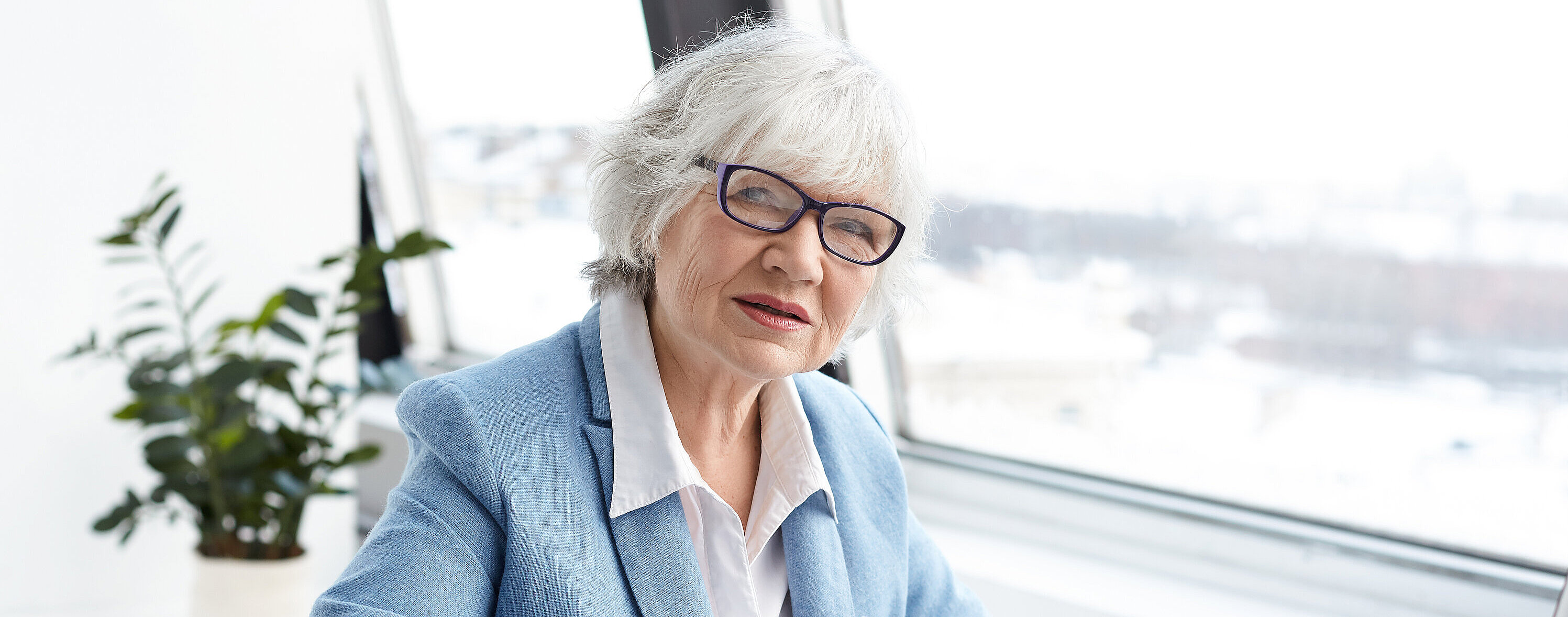 Attractive serious female chief executive officer of mature age sitting at her office with laptop, keyboarding and signing papers on desk, having confident look. People, aging, job and career concept Attractive serious female chief executive officer of mature age sitting at her office with laptop, keyboarding and signing papers on desk, having confident look. People, aging, job and career concept