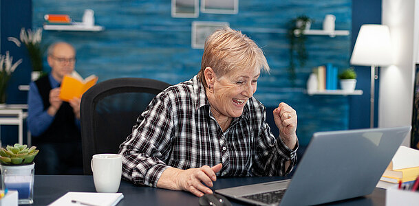Excited mature woman celebrating online purchase