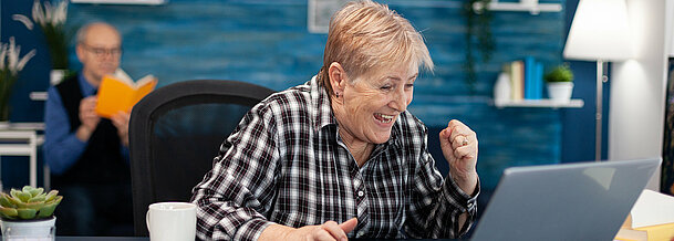 Excited mature woman celebrating online purchase