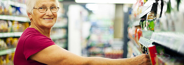 Happy senior woman at supermarket