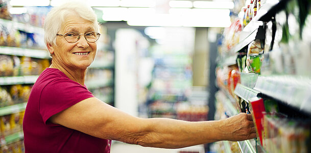 Happy senior woman at supermarket
