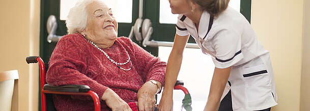 Nurse caring for senior woman in wheelchair