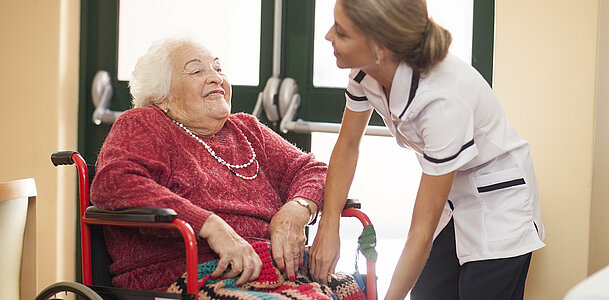 Nurse caring for senior woman in wheelchair
