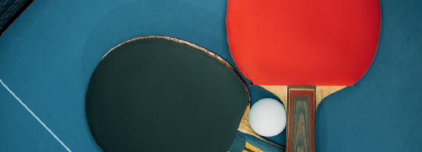 Tischtennisschläger auf einem Tischtennistisch liegend