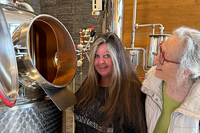 2 Frauen schauen in Öffnung des Maischekessels