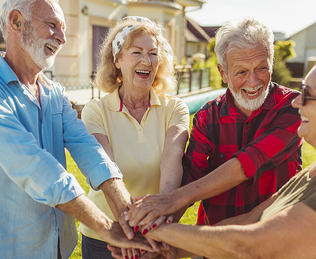 Senior people holding hands in the middle before a football match