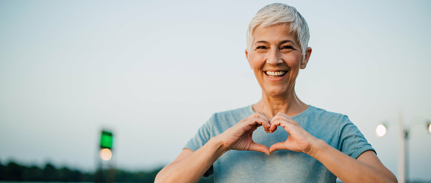 Active senior woman making a heart with her hands