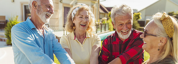 Senior people holding hands in the middle before a football match Senior people holding hands in the middle before a football match