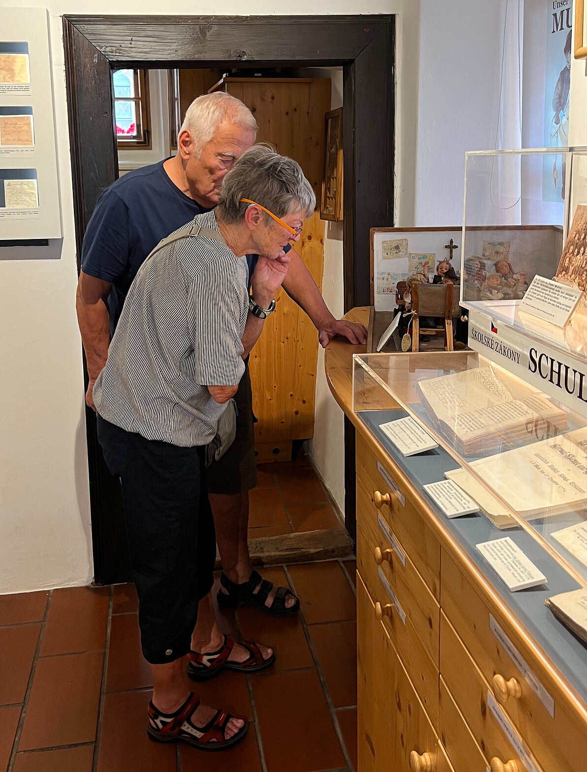 Ein Mann und eine Frau beugen sich über Vitrine