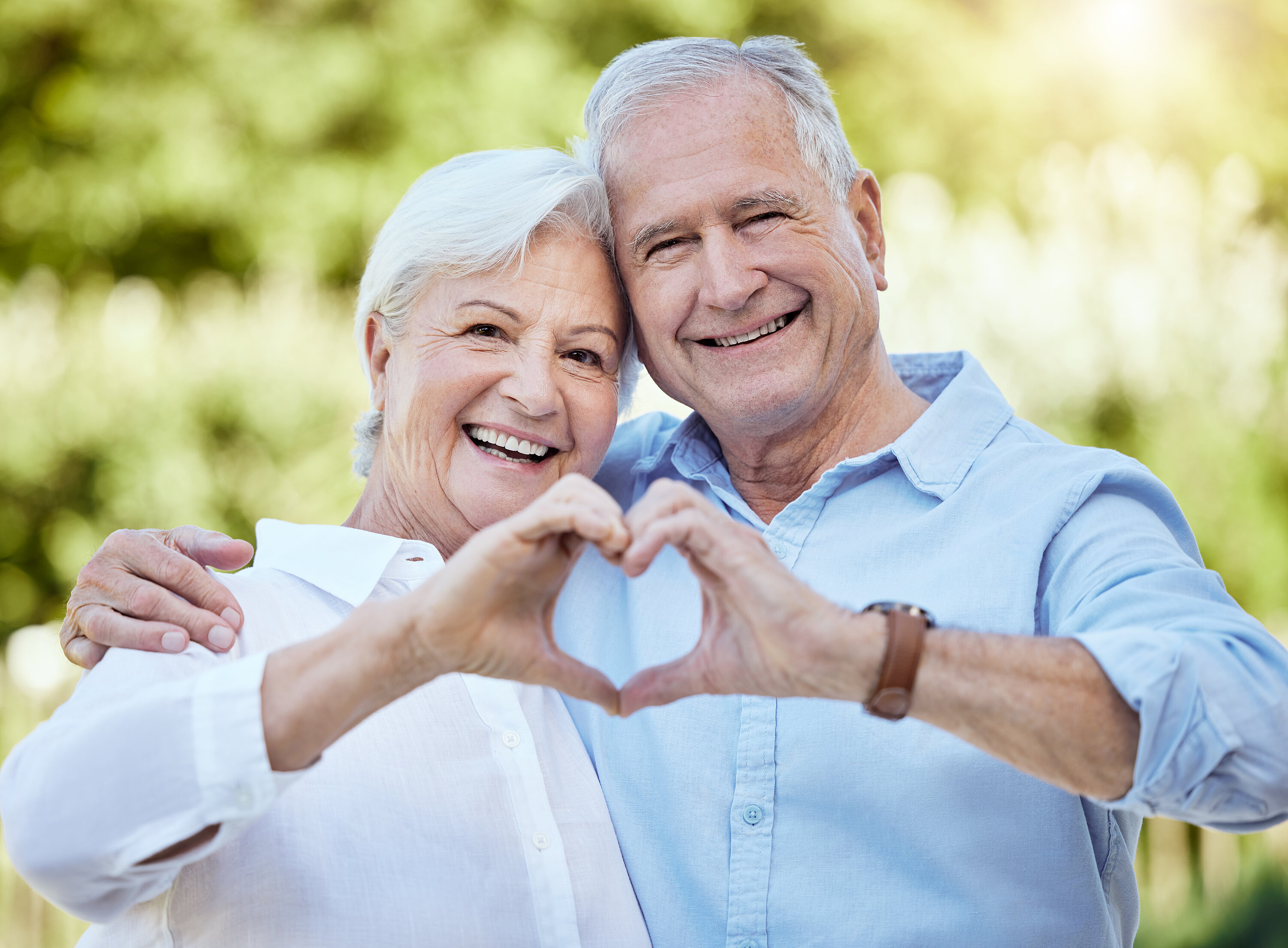 Sujet_Senioren_Pensionisten_Paar_Glücklich_Herz Shot of a senior couple forming a heart shape with their hands while standing outside