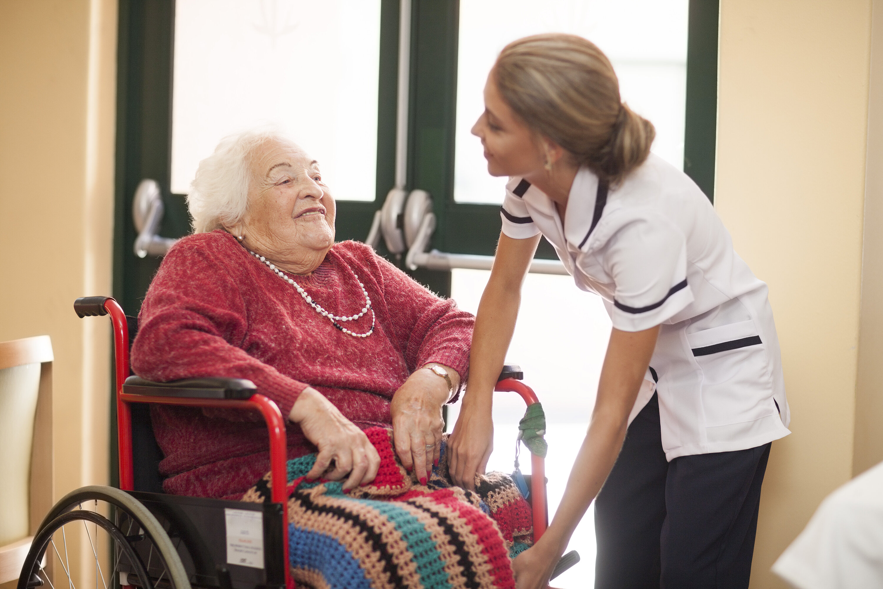 Nurse caring for senior woman in wheelchair Nurse caring for senior woman in wheelchair